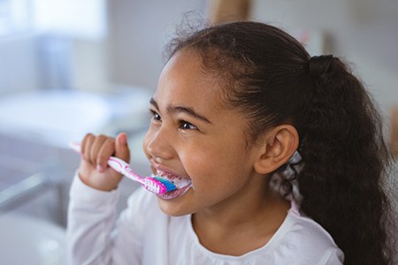 Young girl brushing her teeth at home