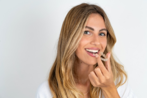 a closeup of a patient holding a clear aligner