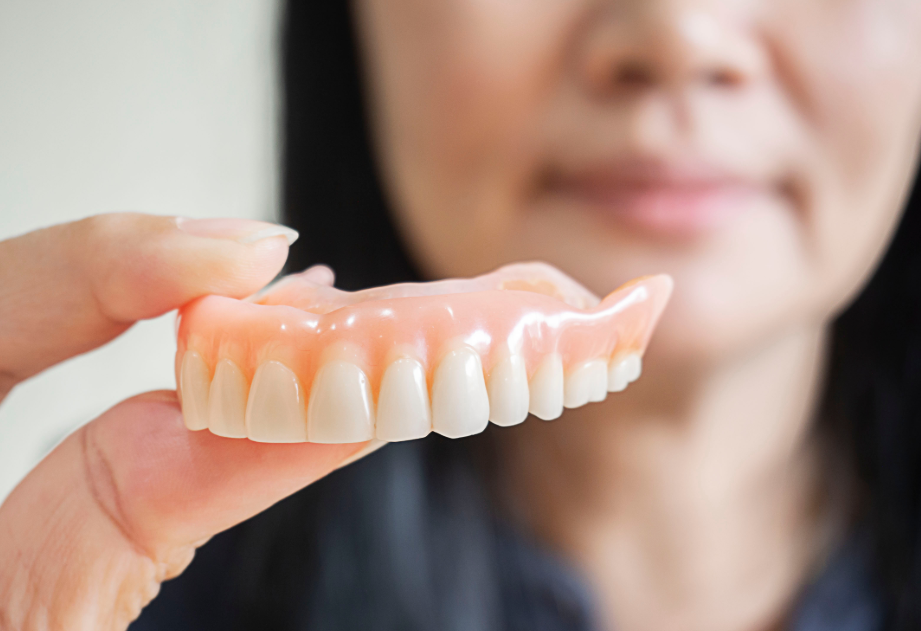 Woman holding denture
